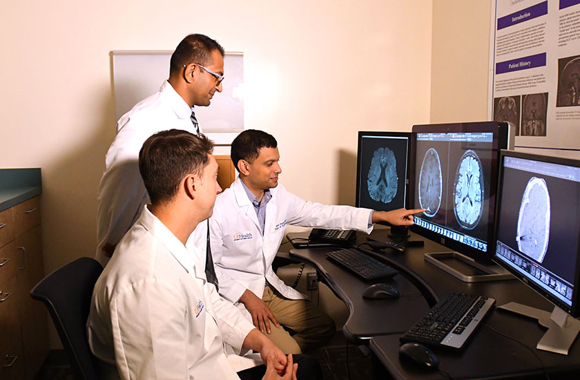 University of Florida neuroradiologists and neuroradiology fellows looking at cranial imaging at UF Health Jacksonville